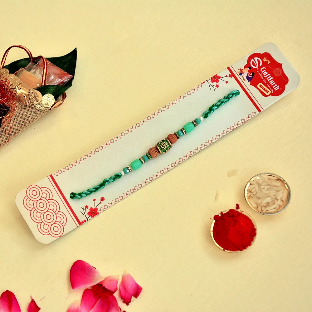 Sacred Swastik Rakhi – RK-130 | Green Thread with Aqua Beads & Spiritual Centerpiece