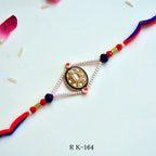 Kundan Oval Rakhi – RK-164 | Traditional Rakhi with Pearl Beads & Blue Thread Detailing for Brother