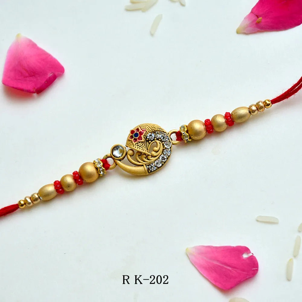 Ethnic Golden Crescent Rakhi – RK-202 | Intricate Motif, Studded Stones & Red-Gold Beads
