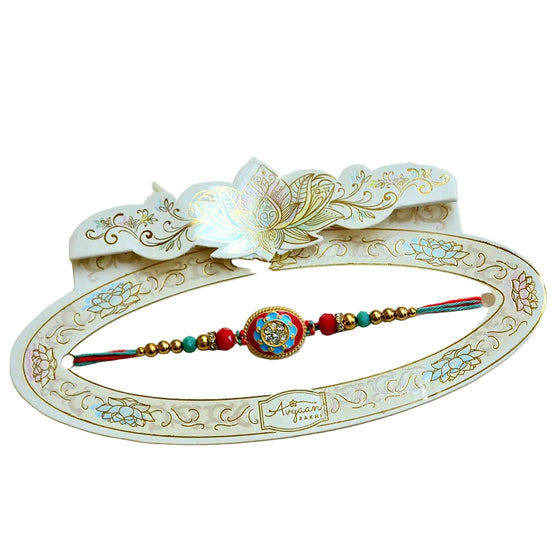 Vibrant Oval Meenakari Rakhi – RK-205 | Red & Blue Enamel Rakhi with Crystal Studded Centerpiece