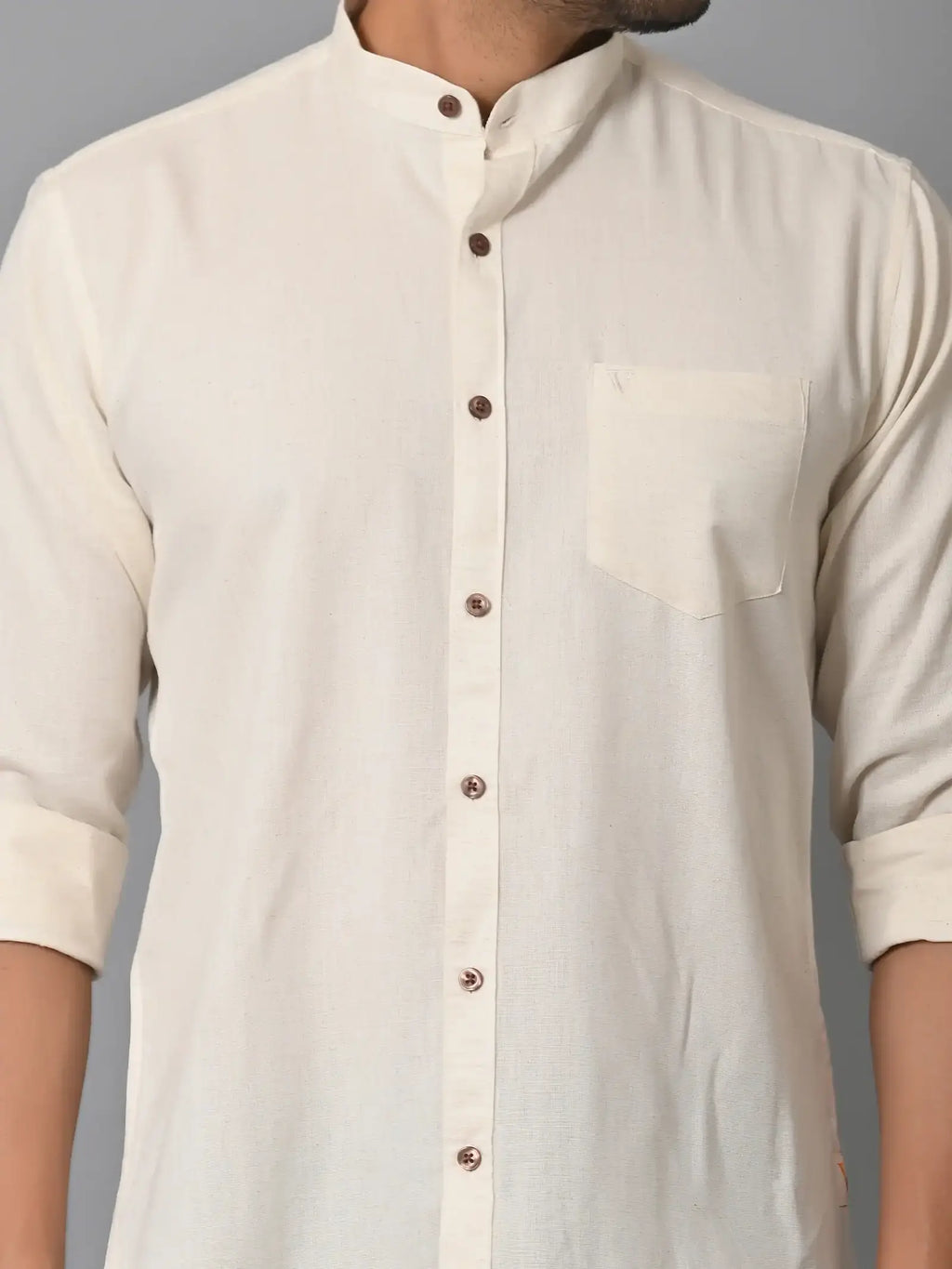 Soft cream-colored men's casual shirt with brown buttons and a chest pocket, made from eco-friendly fabrics, perfect for stylish sustainable fashion.