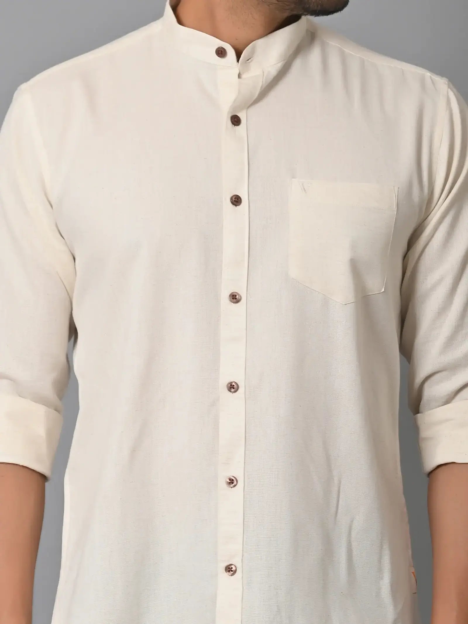 Soft cream-colored men's casual shirt with brown buttons and a chest pocket, made from eco-friendly fabrics, perfect for stylish sustainable fashion.