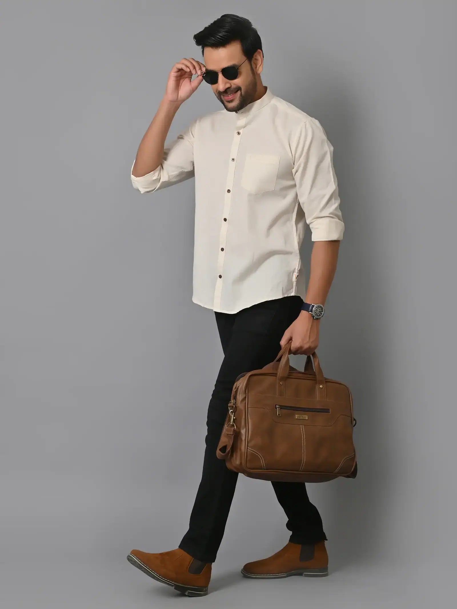 Men's stylish professional attire with a white shirt, black pants, brown leather shoes, and sunglasses, carrying a brown leather briefcase, showcasing business fashion and accessories.