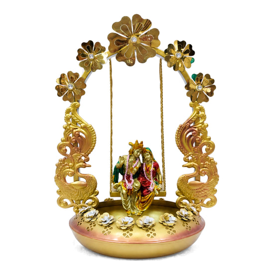 Elegant Golden Metal Radha Krishna Jhula Idol with Illuminated Floral Arch and Peacock Urli Base I-413-A