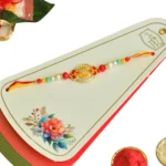Golden Emblem Rakhi – RK-46 | Oval Centerpiece with Red Accents & Multicolor Bead Detailing - Image 4