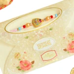 Vibrant Shield Rakhi – RK-59 | Rainbow Accents on Golden Base with Soft-Tone Thread - Image 4
