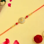 Royal Ganesha Coin Rakhi – RK-112 | Crystal-Studded Medallion with Golden & Red Bead Accents