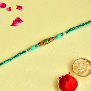Sacred Swastik Rakhi – RK-130 | Green Thread with Aqua Beads & Spiritual Centerpiece
