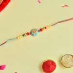 Turquoise Traditional Rakhi – RK-55 | Red-Blue Thread with Golden Beads & Enamel Center