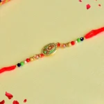 Classic Red Thread Rakhi – RK-62 | Handcrafted Oval Dial with Multicolor Beads