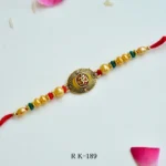 Divine Om Rakhi – RK-189 | Traditional Rakhi with Golden Beads & Sacred Om Emblem