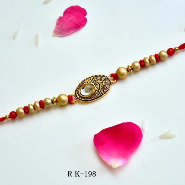 Royal Touch Rakhi – RK-198 | Gold Oval Designer Rakhi with Embedded Crystal & Intricate Detailing