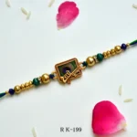 Peacock Grace Rakhi – RK-199 | "Shree Krishna" Script & Peacock Feather Design in Antique Gold Frame