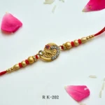 Ethnic Golden Crescent Rakhi – RK-202 | Intricate Motif, Studded Stones & Red-Gold Beads