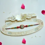 Vibrant Oval Meenakari Rakhi – RK-205 | Red & Blue Enamel Rakhi with Crystal Studded Centerpiece - Image 2