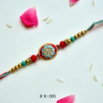 Vibrant Oval Meenakari Rakhi – RK-205 | Red & Blue Enamel Rakhi with Crystal Studded Centerpiece