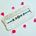 Royal Azure Pearl Rakhi – RK-229 | Floral Centerpiece with White Pearls & Blue Crystal Beads - Image 2