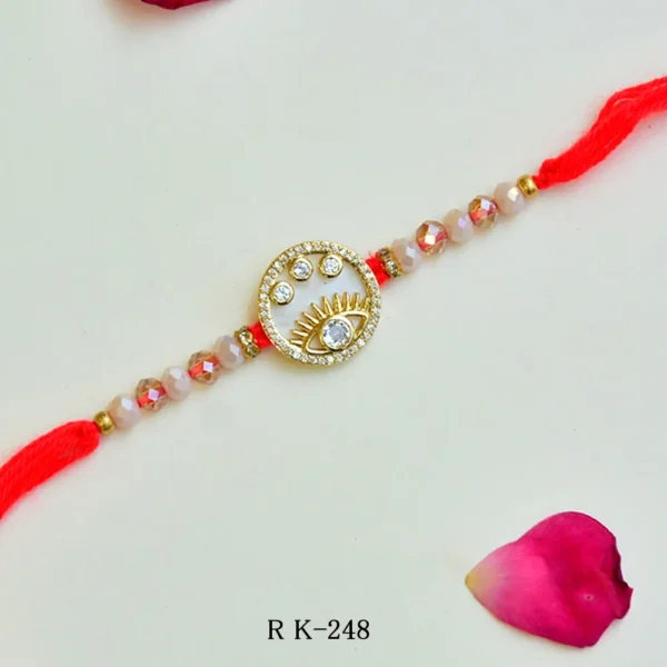 Eye Motif Designer Rakhi – RK-248 | Red Thread with Crystal Beads and Gold Accents - Image 1