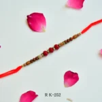RK-252 | Traditional Rudraksha Rakhi with Red Crystal Beads & Golden Spacers (Set of 12)